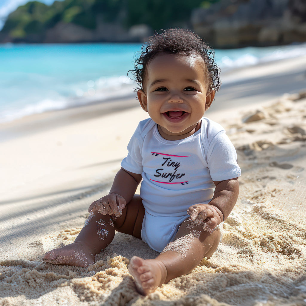 Tiny surfer white baby onesie on baby on the beach